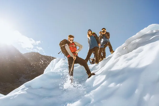 Wanderer in Steigeisen steigen einen verschneiten Grat auf dem Fox Glacier hinauf